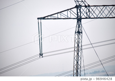 High voltage tower with electric power lines divided by safe guard bushing transfening safely electrical energy through cable wires. Electricity transmission on long distance concept High voltage tower with electric power lines divided by safe guard bushing transfening safely electrical energy through cable wires. Electricity transmission on long distance concept 96946428
