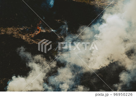 立ち上る野焼きの煙と炎 収穫後の田んぼ　c-3 フィルム調  96950226