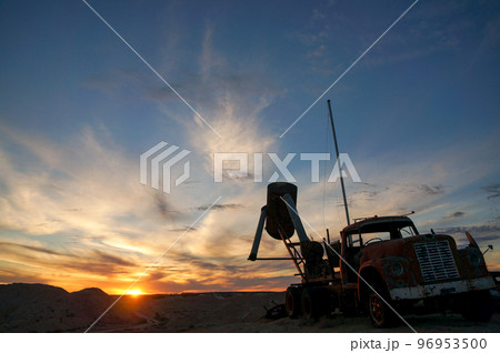 オパール採掘現場の夕日とトラックのシルエット 96953500