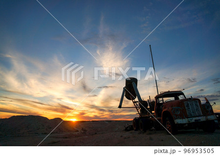 クーバーペディの夕日と廃車のトラックのシルエット 96953505