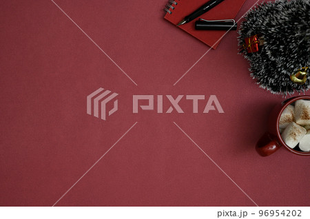 Top view, Red workspace in Christmas theme with copy space, small Christmas tree, hot chocolate Top view, Red workspace in Christmas theme with copy space, small Christmas tree, hot chocolate 96954202