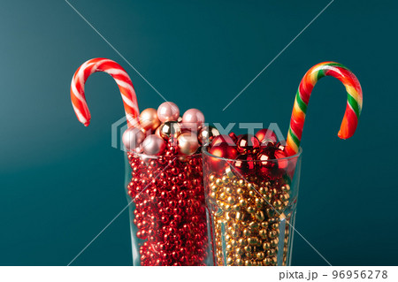 Glass cups with Christmas decor against dark green background Glass cups with Christmas decor against dark green background 96956278