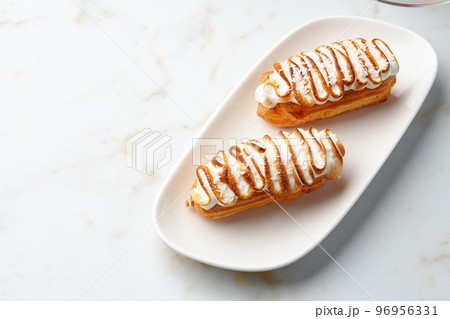 Eclairs with cream decorating of Swiss meringue frosting Eclairs with cream decorating of Swiss meringue frosting 96956331