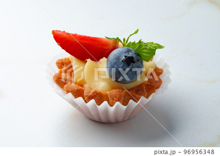 Tartalette with boiled milk cream and berries on white table 96956348