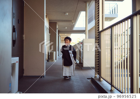 七五三のお宮参りに向かうために、マンションの廊下でエレベーターを待っている5歳男児 七五三のお宮参りに向かうために、マンションの廊下でエレベーターを待っている5歳男児 96956525