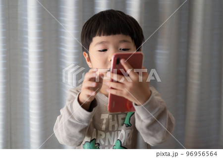 スマートフォンの操作をしながら、なにやら話している5歳男児 スマートフォンの操作をしながら、なにやら話している5歳男児 96956564
