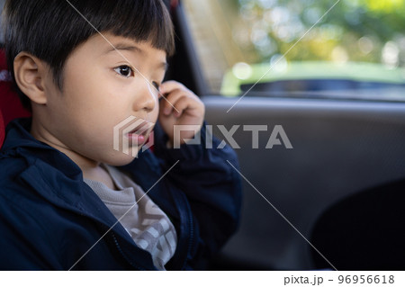 車に乗ってお出かけ中、ちょっと眠いのか目を擦っている5歳男児 車に乗ってお出かけ中、ちょっと眠いのか目を擦っている5歳男児 96956618
