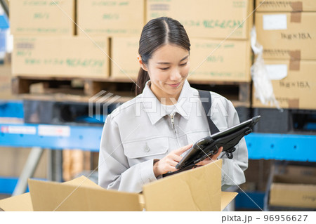 倉庫で検品をする若い女性の作業員 倉庫で検品をする若い女性の作業員 96956627