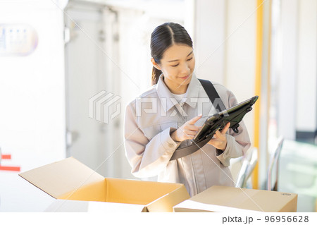 倉庫で検品をする若い女性の作業員 倉庫で検品をする若い女性の作業員 96956628