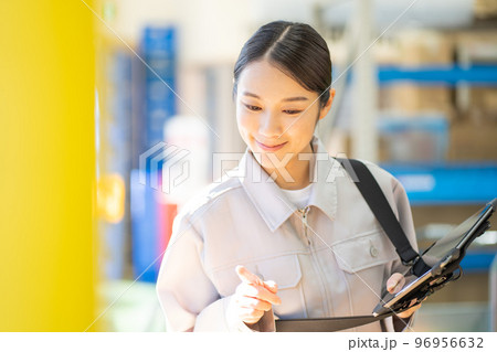 倉庫で検品をする若い女性の作業員 倉庫で検品をする若い女性の作業員 96956632