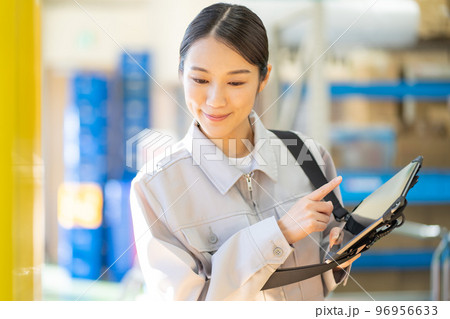 倉庫で検品をする若い女性の作業員 倉庫で検品をする若い女性の作業員 96956633
