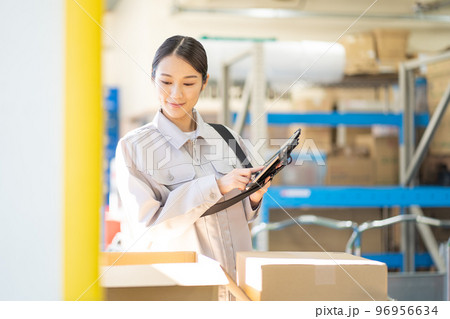 倉庫で検品をする若い女性の作業員 倉庫で検品をする若い女性の作業員 96956634