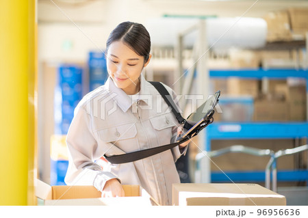 倉庫で検品をする若い女性の作業員 96956636