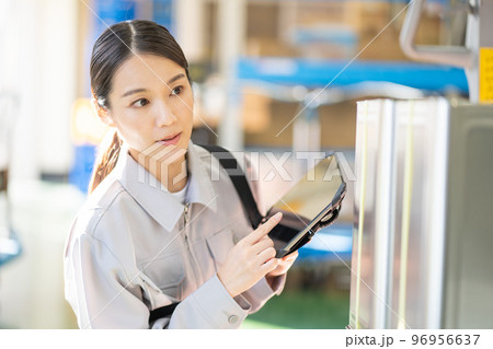 倉庫で検品をする若い女性の作業員 96956637