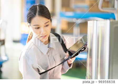 倉庫で検品をする若い女性の作業員 倉庫で検品をする若い女性の作業員 96956638
