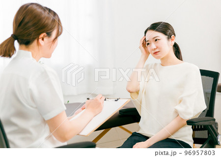 病院・整骨院・整体院で頭痛で悩む患者を診察・問診・カウンセリングする女性医師・看護師 病院・整骨院・整体院で頭痛で悩む患者を診察・問診・カウンセリングする女性医師・看護師 96957803