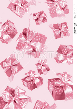 Creative background of flying present boxes. Any holiday shopping, sales advertisement. Vertical format. Trendy toning in color 2023 Viva Magenta. 96958698