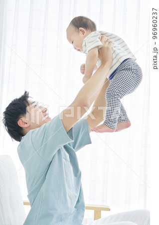 家で赤ちゃんを高い高いする父親 96960237