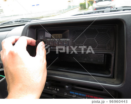 自動車の車載ラジオの音量をつまみを回して調整する 96960443
