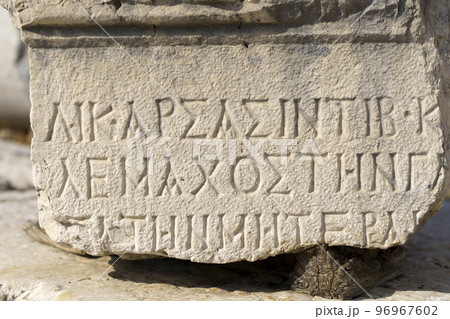 Antique greek inscriptions carved on the stone of the old ruins of an antique greek city 96967602