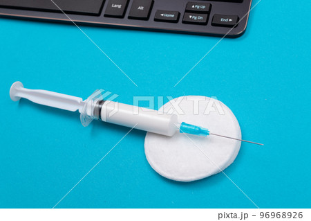 Vaccination or Revaccination Concept - A Medical Syringe on Blue Table Vaccination or Revaccination Concept - A Medical Syringe on Blue Table 96968926