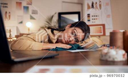 Fashion designer, stress and sleeping on studio table in deadline pressure, startup fail or small business anxiety. Tired, asleep and exhausted creative in clothes workshop, mental health or burnout Fashion designer, stress and sleeping on studio table in deadline pressure, startup fail or small business anxiety. Tired, asleep and exhausted creative in clothes workshop, mental health or burnout 96970032