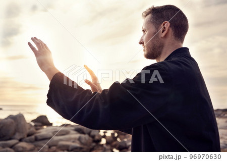 Meditation, peace and tai chi with man at beach for fitness, spiritual and healing energy. Relax, wellness and health with guy training with breathing exercise for zen, balance and martial arts 96970630