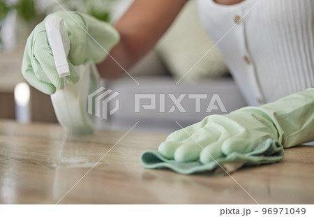 Woman, spray bottle and sanitizer cleaning with a cleaner wiping a table surface with a cloth or rag in the home. Hands, spraying and disinfectant with a female clean bacteria and house work on desk Woman, spray bottle and sanitizer cleaning with a cleaner wiping a table surface with a cloth or rag in the home. Hands, spraying and disinfectant with a female clean bacteria and house work on desk 96971049