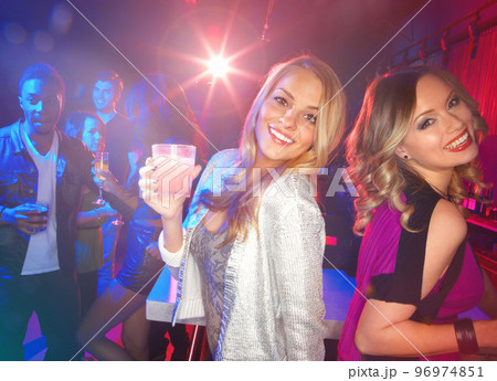 Portrait, party and nightclub with woman friends together at a new year celebration event at night. Birthday, cocktail and music with a female and friend dancing or bonding in a club for happy hour 96974851