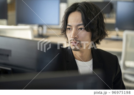 パソコンのディスプレイを見つめる30代前半の男性 パソコンのディスプレイを見つめる30代前半の男性 96975198