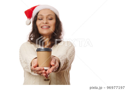 Details: hands of pretty woman, holding out on camera a takeaway hot tea or coffee in recyclable eco paper cup, isolated on white background. Coffee shops concept. Beverage to go. Mockup. Copy space Details: hands of pretty woman, holding out on camera a takeaway hot tea or coffee in recyclable eco paper cup, isolated on white background. Coffee shops concept. Beverage to go. Mockup. Copy space 96977197