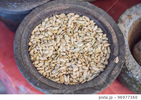 Pods of green cardamom in a large pottery 96977360