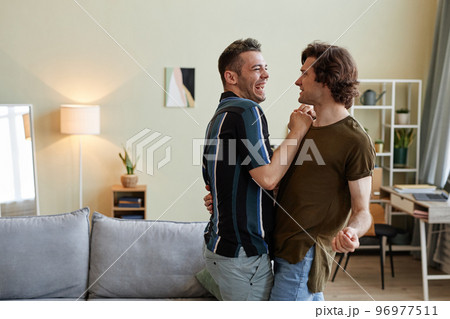 Carefree gay couple dancing at home Carefree gay couple dancing at home 96977511