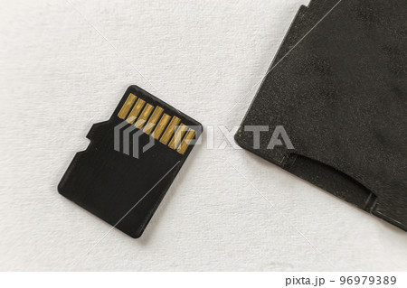 Close-up of micro SD memory card and SD adapter isolated on white copy space background. Modern technology concept. Close-up of micro SD memory card and SD adapter isolated on white copy space background. Modern technology concept. 96979389