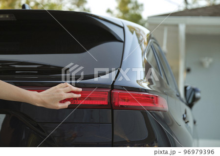Close-up of human hand on rear car stoplight, checkout before driving. Safety travel concept Close-up of human hand on rear car stoplight, checkout before driving. Safety travel concept 96979396