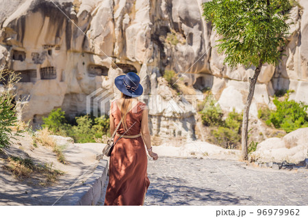Young woman exploring valley with rock formations and fairy caves near Goreme in Cappadocia Turkey 96979962