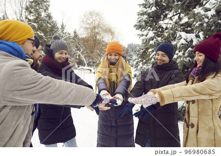 Happy friends join hands together relax on winter weekend 96980685