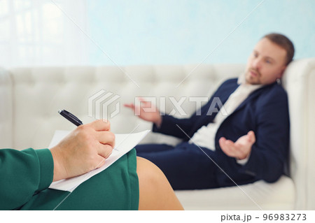 Blurred of young businessman sits on sofa talking to his therapist at therapy session Blurred of young businessman sits on sofa talking to his therapist at therapy session 96983273