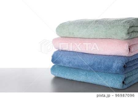 Fresh towels on light grey table against white background 96987096