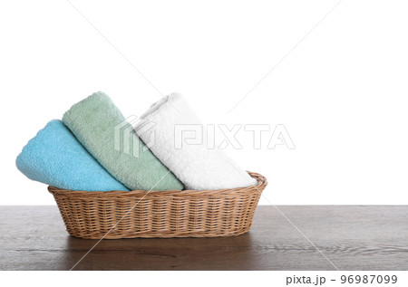 Fresh towels on wooden table against white background Fresh towels on wooden table against white background 96987099