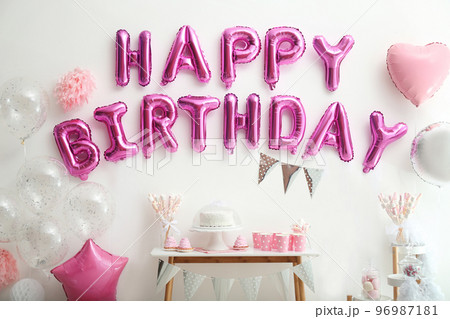 Phrase HAPPY BIRTHDAY made of pink balloon letters on white wall 96987181