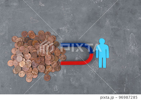 Paper person and magnet attracting coins on grey stone table, flat lay Paper person and magnet attracting coins on grey stone table, flat lay 96987285