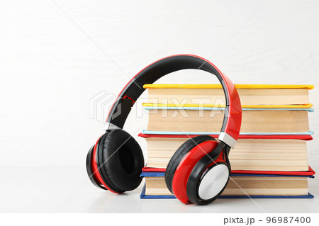 Books and modern headphones on white background. Space for text 96987400