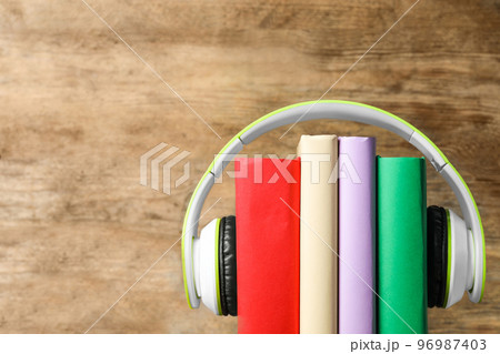 Books and modern headphones on wooden background, closeup. Space for text Books and modern headphones on wooden background, closeup. Space for text 96987403