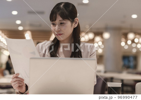 資料を見ながら考える女性 96990477