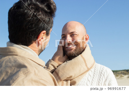 Brunette man touching face of boyfriend 96991677