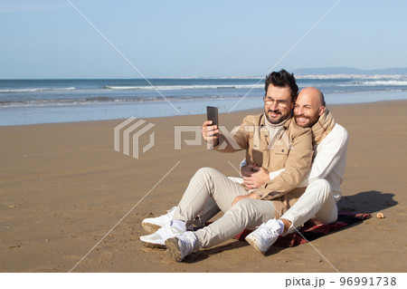 Smiling gay posing with boyfriend for selfie Smiling gay posing with boyfriend for selfie 96991738