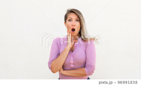 Shocked Caucasian woman touching face 96991838