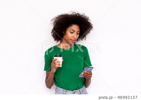 Portrait of serious young woman with coffee reading message Portrait of serious young woman with coffee reading message 96992137