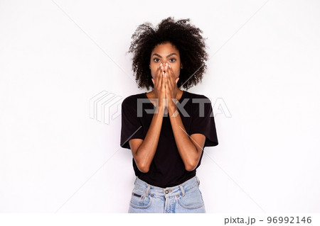 Portrait of ashamed young woman covering mouth with hands 96992146